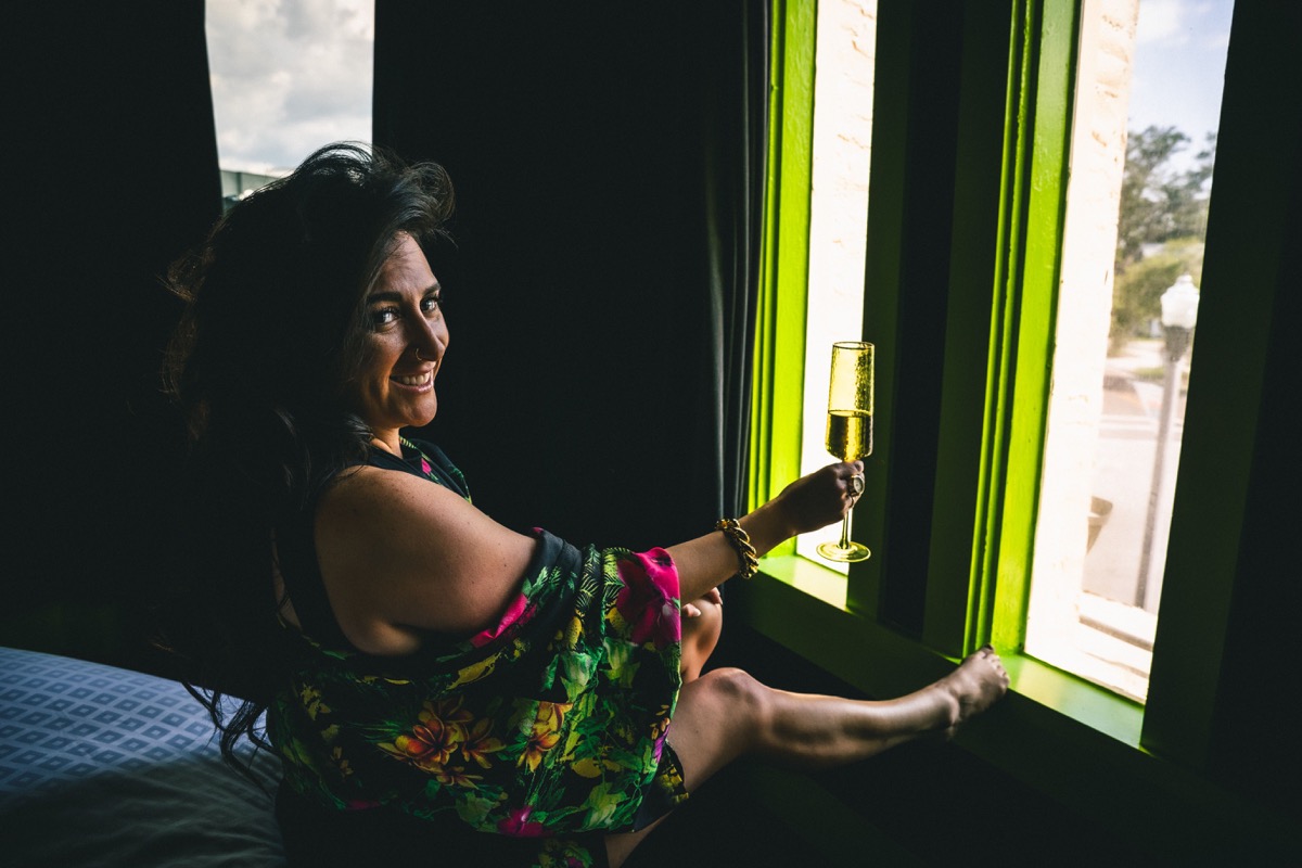 Katie Dickieson smiling with a champagne glass — your host for Canva and Cocktails